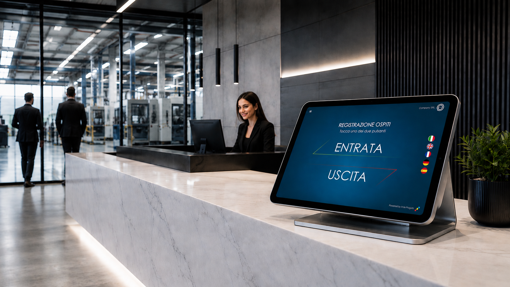 Reception aziendale con il tablet IRIGuest sul bancone, schermata con i pulsanti Entrata e Uscita e le bandiere delle lingue